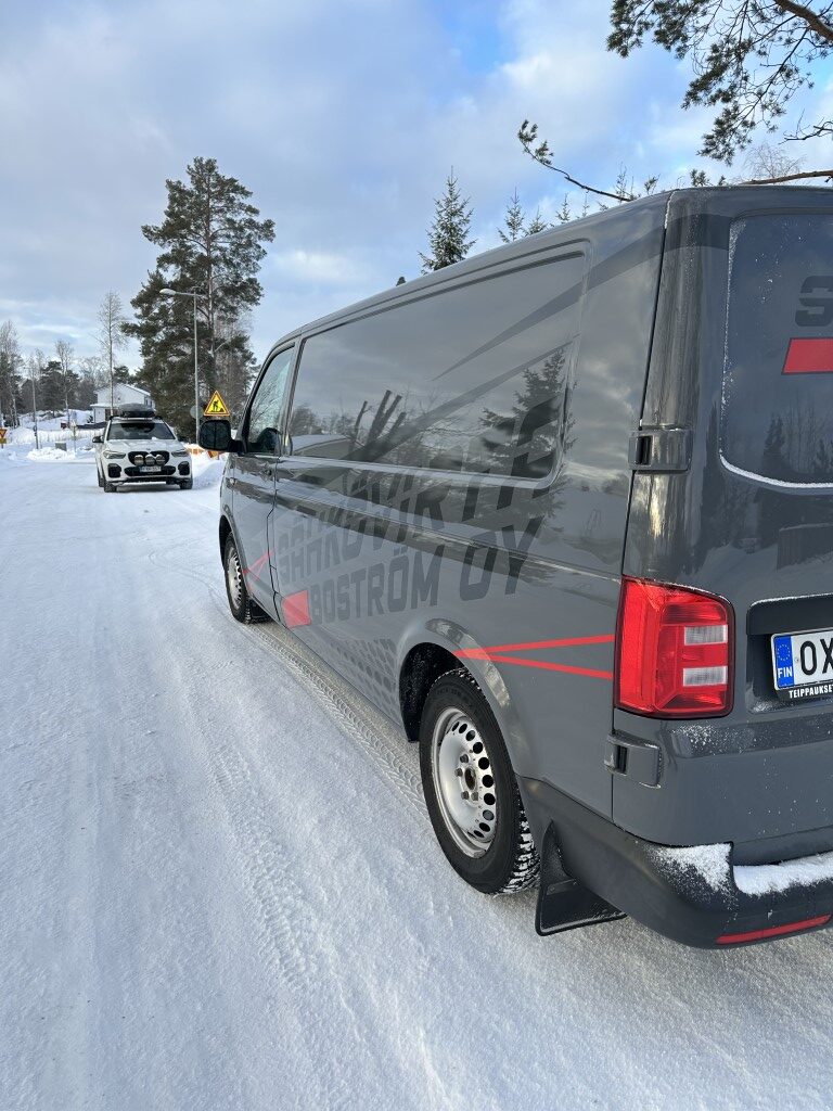 Sähköasennuksia toteuttavan Sähkövirta Boströmin pakettiauto kadun varressa, lumisessa talvimaisemassa