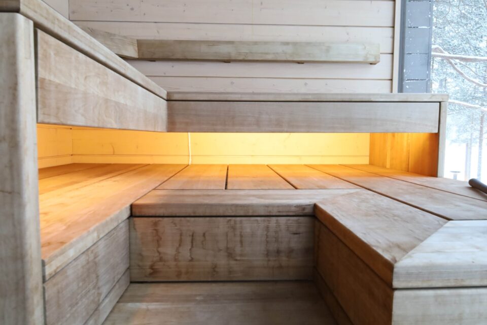 Upeat valaistukset lauteiden alla uudistuneessa modernissa saunassa